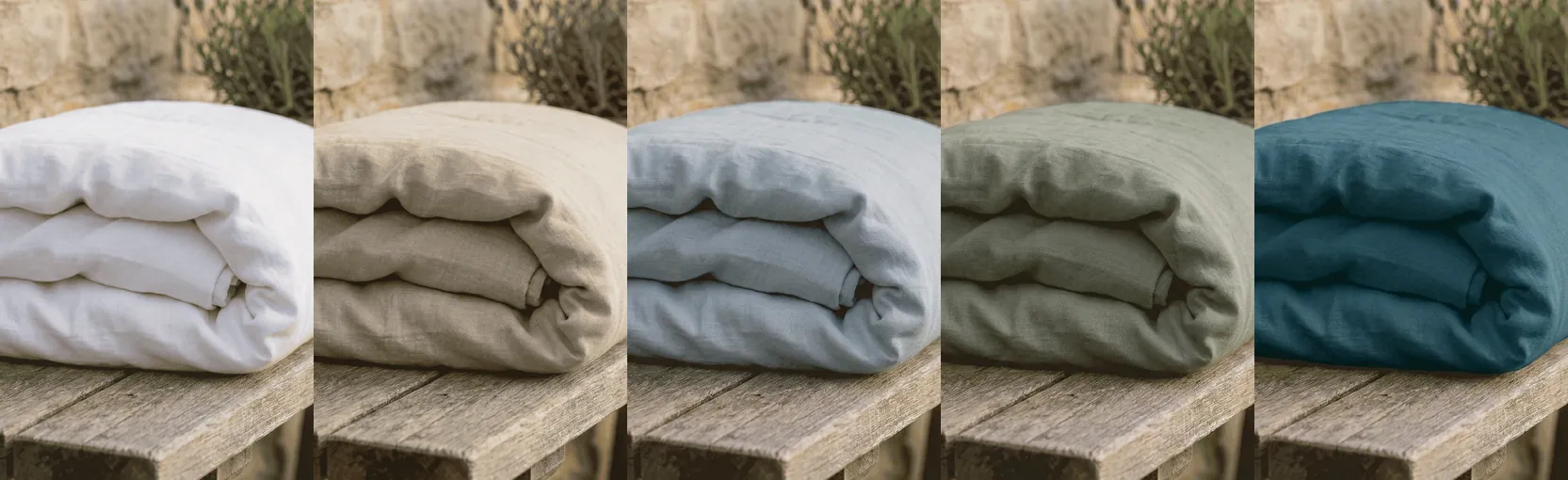 Five folded linen duvet covers side by side: white, oatmeal, dusty blue, forest green and dark teal.